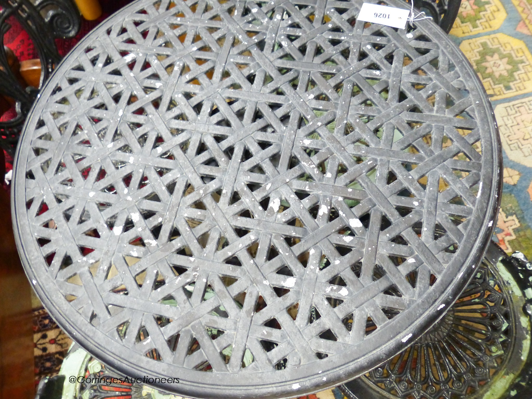 A tilt-top cast metal garden table and four chairs. Table, D-67, H-72cm.